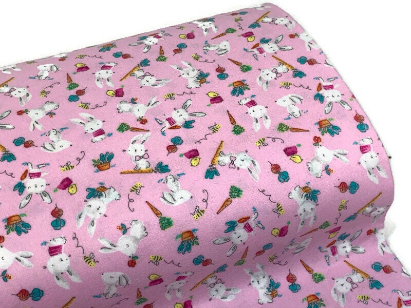 Flannel Bunny Fabric Sold by the YARD. 100% Cotton Easter Fabric. White Rabbits on Pink, Green Accents. For Quilts, Clothing, Nursery Décor.